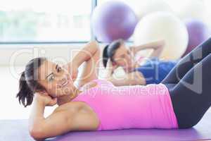 Two fit young women doing pilate exercises