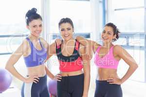 Three fit young women smiling in exercise room