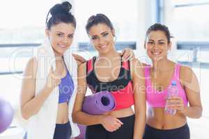 Three fit young women smiling in exercise room