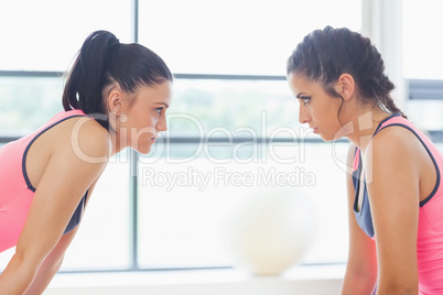 Two angry women staring at each other at a gym