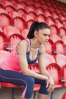 Serious toned woman sitting on chair in the stadium