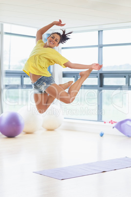 Young woman jumping in fitness studio