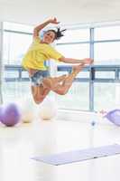 Young woman jumping in fitness studio