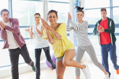 Cheerful fitness class and instructor doing pilates exercise