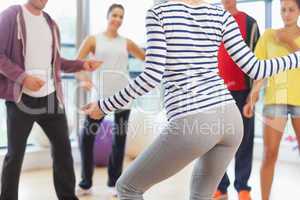 Mid section of fitness class and instructor doing pilates exerci