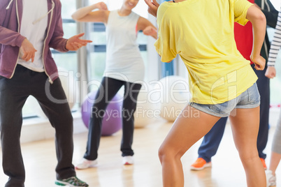 Low section of fitness class and instructor doing pilates exerci