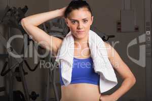 Young woman with towel standing in the gym