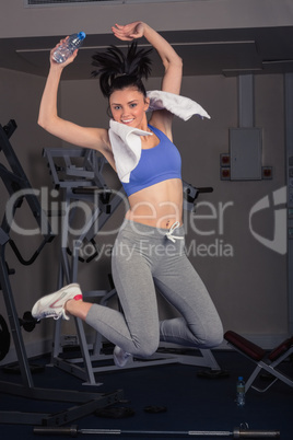 Full length portrait of fit woman jumping in gym