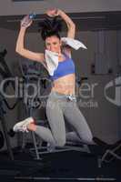 Full length portrait of fit woman jumping in gym
