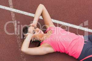 Sporty woman suffering from headache on the running track