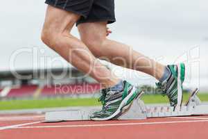 Low section of a man ready to race on running track