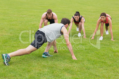 Young people doing stretching exercise at the park