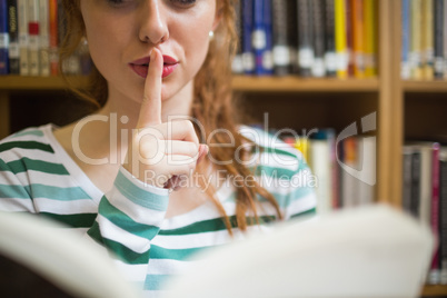 Redhead student asking for silence holding a book Redhead student asking for silence holding a book