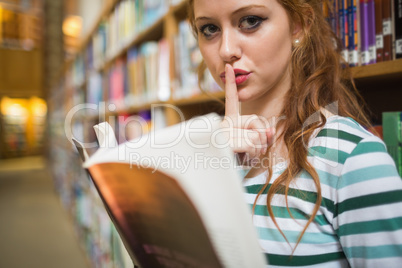 Serious student asking for silence holding a book