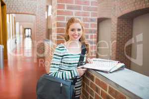 Redhead student smiling at camera in the hall