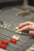 Student working on sound desk adjusting levels