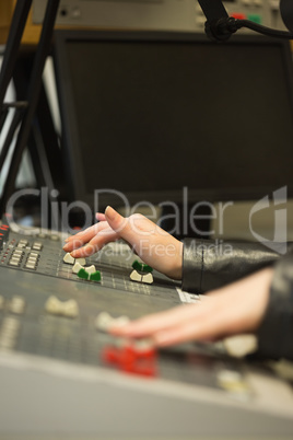 Student working on sound desk adjusting levels in the studio