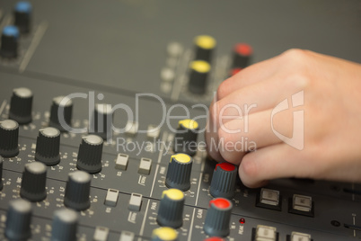 Hand working on a sound mixing desk