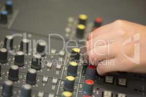 Hand working on a sound mixing desk