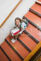 Young student sitting on stairs smiling up at camera