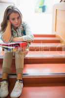 Troubled student sitting on stairs