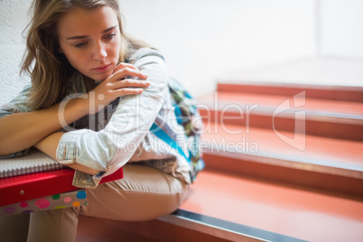 Sad lonely student sitting on stairs