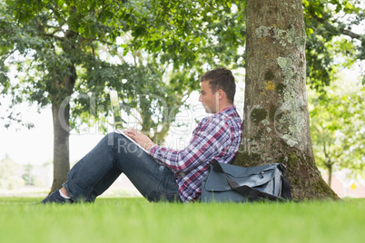Young student using his laptop to study outside