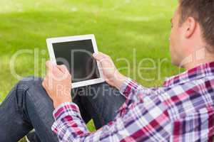 Happy student using his tablet outside