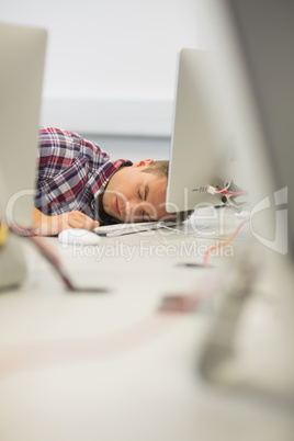 Handsome student sleeping in the computer room