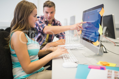 Smiling classmates doing an assignment together in the computer