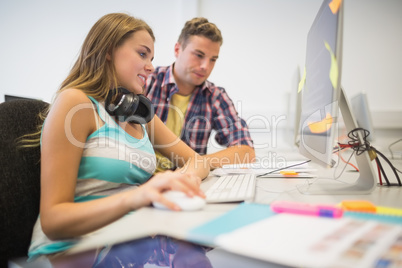 Cheerful classmates doing an assignment together in the computer
