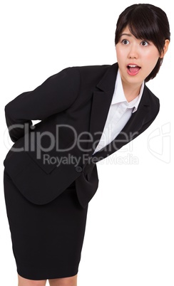 Surprised businesswoman bending