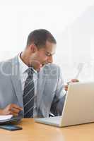 Young businessman shouting into the phone at office