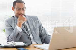 Businessman sitting with laptop at office desk