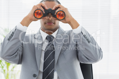 Businessman looking through binoculars