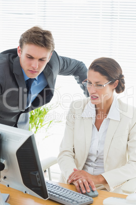 Smartly dressed business couple using computer