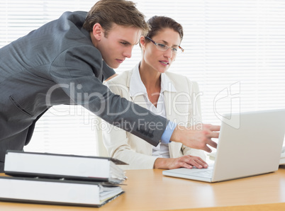 Concentrated business couple using laptop