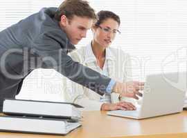 Concentrated business couple using laptop