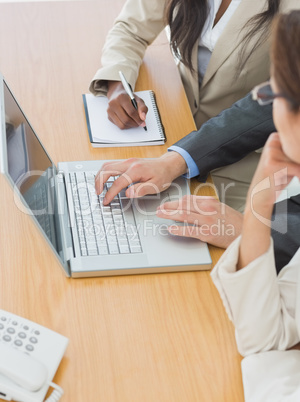 Business colleagues using laptop at office desk