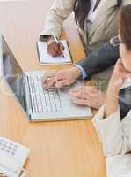 Business colleagues using laptop at office desk