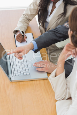 Business colleagues using laptop at desk