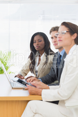 Colleagues with laptop and digital tablet in meeting at desk