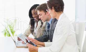 Business colleagues using laptop and digital tablet at desk