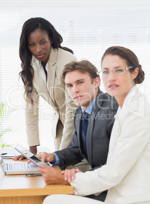 Colleagues with laptop and digital tablet in meeting