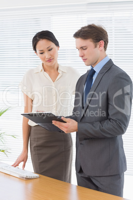 Business colleagues with clipboard at office