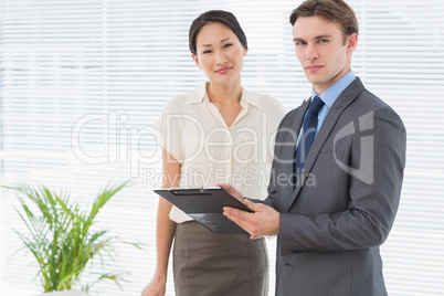 Business colleagues with clipboard at office