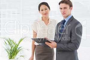 Business colleagues with clipboard at office