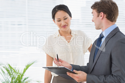 Business colleagues with clipboard at office