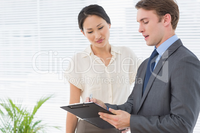 Business colleagues with clipboard at office