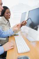 Business colleagues using computers at desk